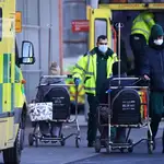 Enfermeros trasladan a pacientes en ambulancias ante el aumento de la presión hospitalaria en Reino Unido