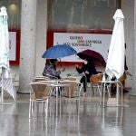 Una pareja se protege de la lluvia en Valladolid