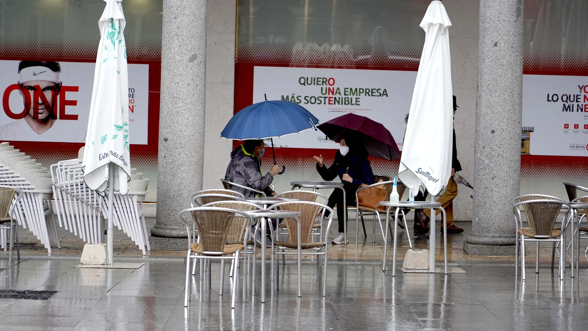 Una pareja se protege de la lluvia en Valladolid