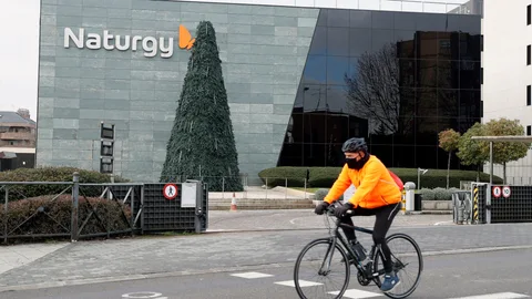 Un ciclista pasa ante la sede de Naturgy en Madrid