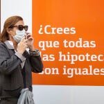 Una mujer pasa por delante de un banco que anuncia hipotecas