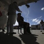 A healthcare worker collects a nasal swab sample to test for COVID-19, in Bogota, Colombia, Wednesday, Jan. 27, 2021. The Colombian government announced that the first shipment of new coronavirus vaccines will arrive in February. (AP Photo/Fernando Vergara)