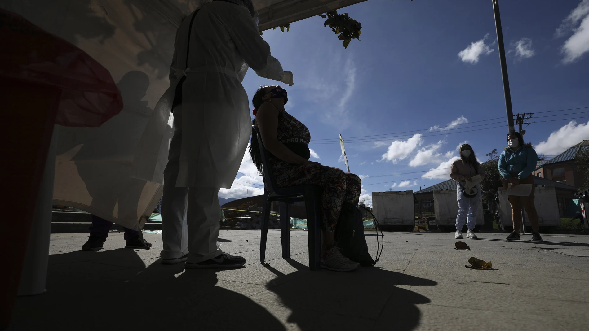 A healthcare worker collects a nasal swab sample to test for COVID-19, in Bogota, Colombia, Wednesday, Jan. 27, 2021. The Colombian government announced that the first shipment of new coronavirus vaccines will arrive in February. (AP Photo/Fernando Vergara)