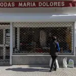 Una mujer observa el escaparate de una tienda de ropa en La Algaba (Sevilla). María José López / Europa Press