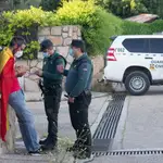 La Guardia Civil identifica a una persona arropada con una bandera de España cerca de la vivienda del vicepresidente Pablo Iglesias.