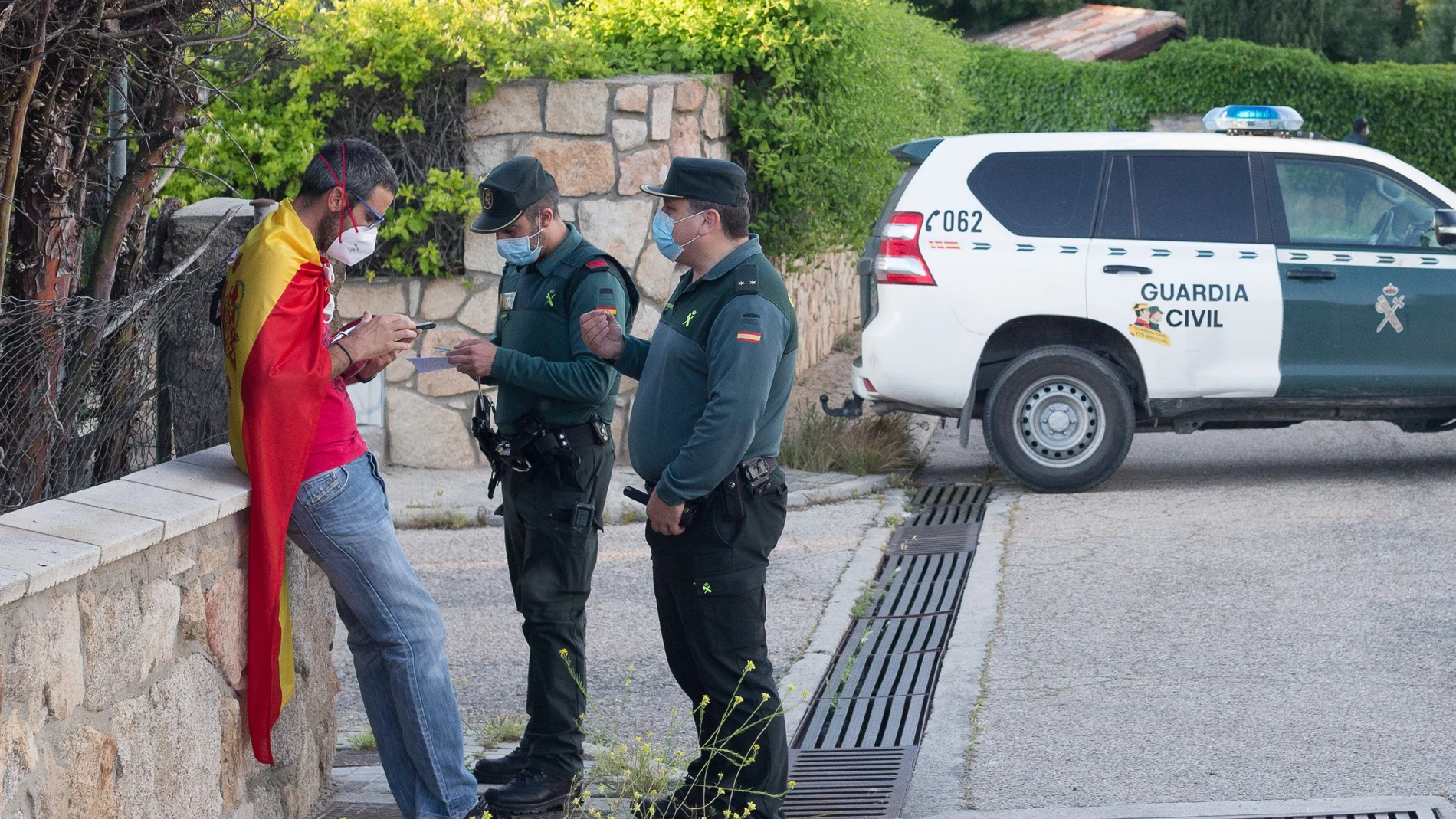 La Guardia Civil identifica a una persona arropada con una bandera de España cerca de la vivienda del vicepresidente Pablo Iglesias.