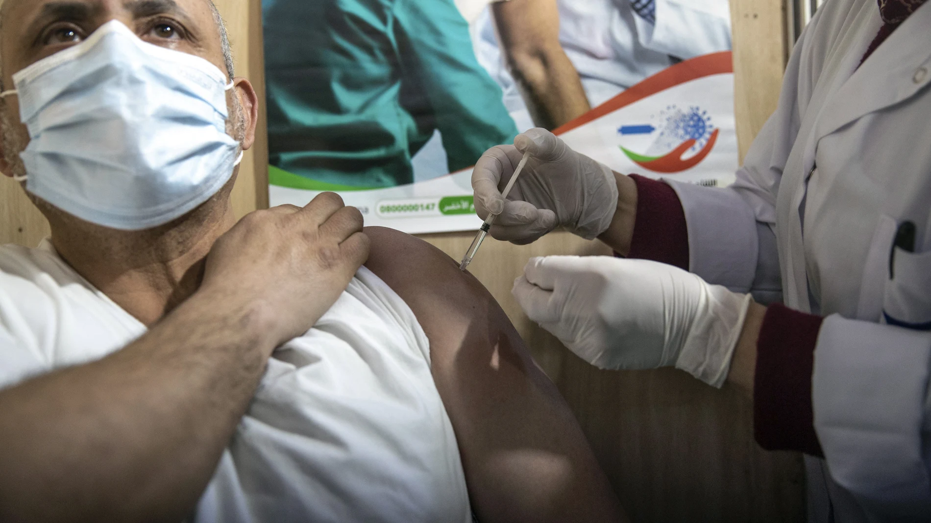 Una enfermera marroquí administra la vacuna AstraZeneca a un profesional sanitario en Rabat