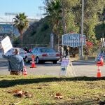 Manifestantes sosteniendo pancartas cerca de la entrada del centro de vacunación en el Estadio de los Dodgers en Los Ángeles. Fuente: @DAVEEDKAPOOR