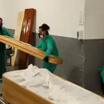 Dos trabajadoras de la funeraria trasladan los restos mortales de una víctima de Covid en el Tanatorio de Sancho d´Avila de Barcelona