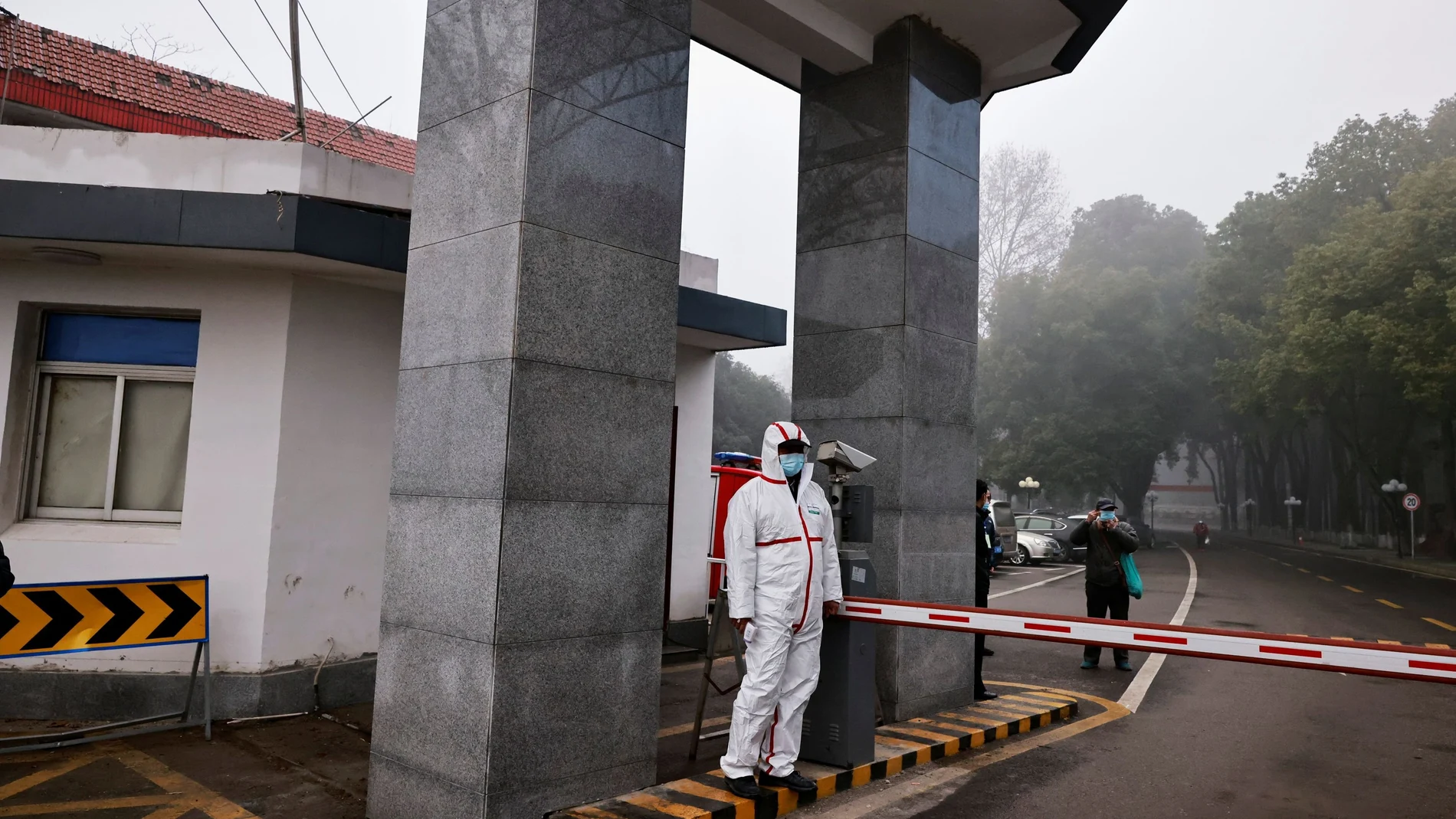 Security personnel look on during the visit by members of the World Health Organization (WHO) team tasked with investigating the origins of the coronavirus disease (COVID-19), at the Hubei provincial center for disease control in Wuhan, China February 1, 2021. REUTERS/Thomas Peter