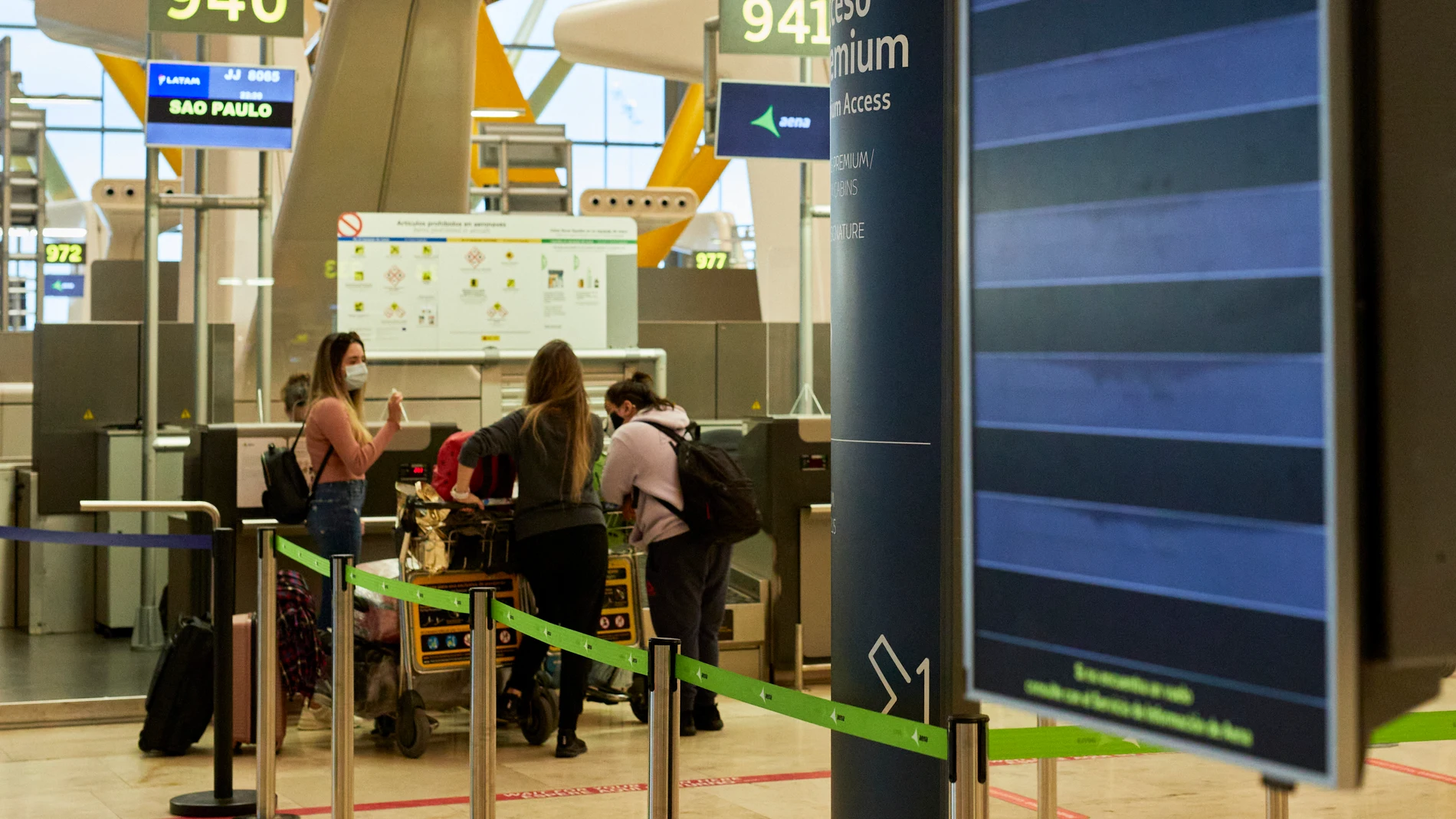 Varias personas facaturan su equipaje en la terminal T4 del Aeropuerto Adolfo Suárez Madrid-Barajas el mismo día en que se restringen los vuelos procedentes de Brasil y Sudáfrica, en Madrid
