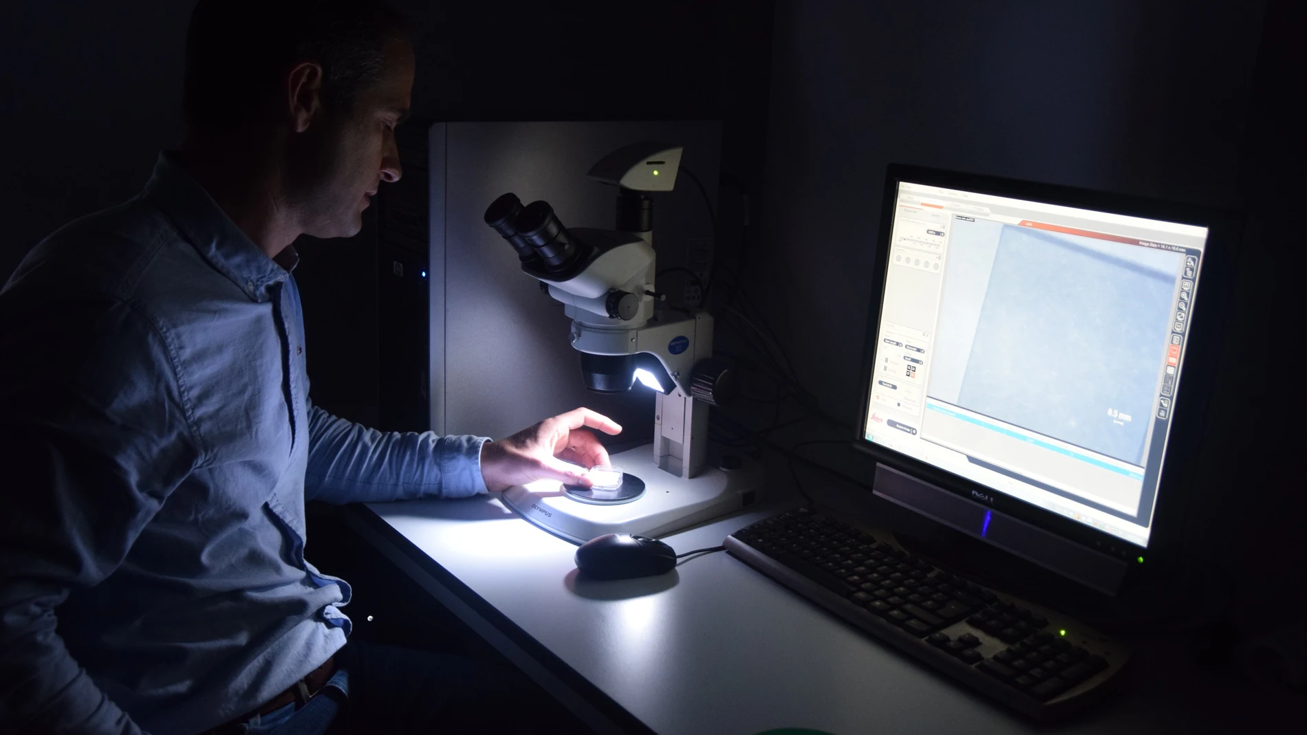 El investigador de la UPCT Javier Prior observando con una lupa de microscopio el diamante que utiliza para mejorar la resolución de las resonancias magnéticas