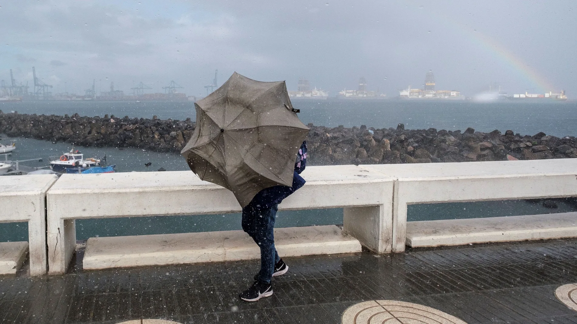 GRAFCAN4724. LAS PALMAS DE GRAN CANARIA (ESPAÑA).-- Una persona intenta avanzar ante el fuerte viento y la lluvia en la capital grancanaria,