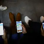 Jóvenes mirando el móvil en la calle