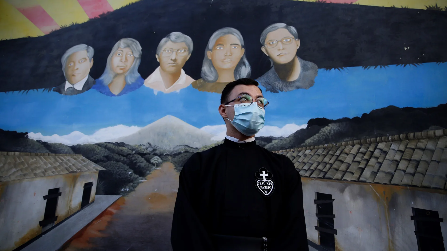 Un sacerdote posa ante un mural dedicado a los mártires de la iglesia salvadoreña que fueron asesinados durante la guerra civil