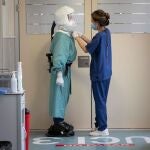 Una enfermera ajusta el Equipo de Protección Personal (EPI) a un enfermero antes de entrar a un box de la Unidad de Cuidados Intensivos (UCI) del Hospital Santa Lucia de Cartagena