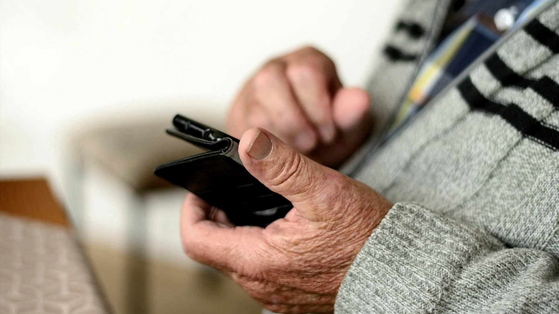 Imagen de un hombre de edad avanzada mirando un móvil