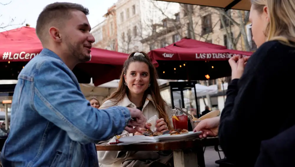 Viajeros franceses disfrutan de unas tapas en una terraza del centro de Madrid durante su semana de vacaciones