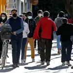 Varias personas protegidas con mascarillas por la ciudad de Valencia