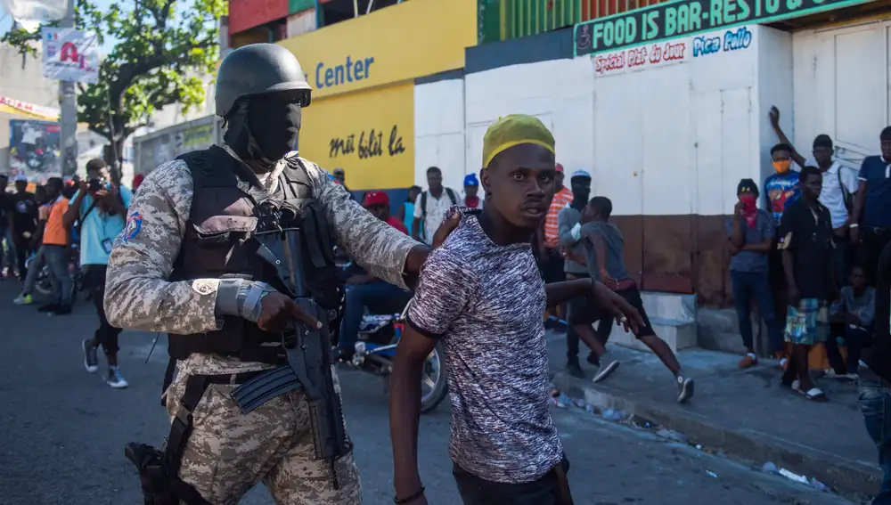 Un policía detiene a un hombre durante unas protestas para forzar la renuncia del presidente de Haití, Jovenel Moise
