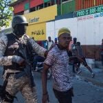 Un policía detiene a un hombre durante unas protestas para forzar la renuncia del presidente de Haití, Jovenel Moise