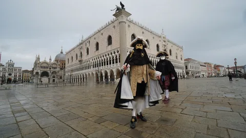 Dos actores disfrazados frente al Palacio Ducal