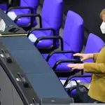 Angela Merkel habla con el epidemiólogo Karl Lauterbach en el parlamento alemán