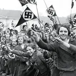 Miembros de la Liga de Mujeres Alemanas ondean banderas nazis en apoyo de la anexión alemana de Austria. marzo de 1938.