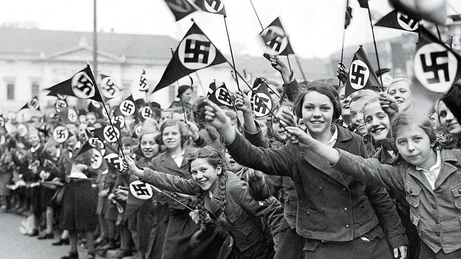 Miembros de la Liga de Mujeres Alemanas ondean banderas nazis en apoyo de la anexión alemana de Austria. marzo de 1938.