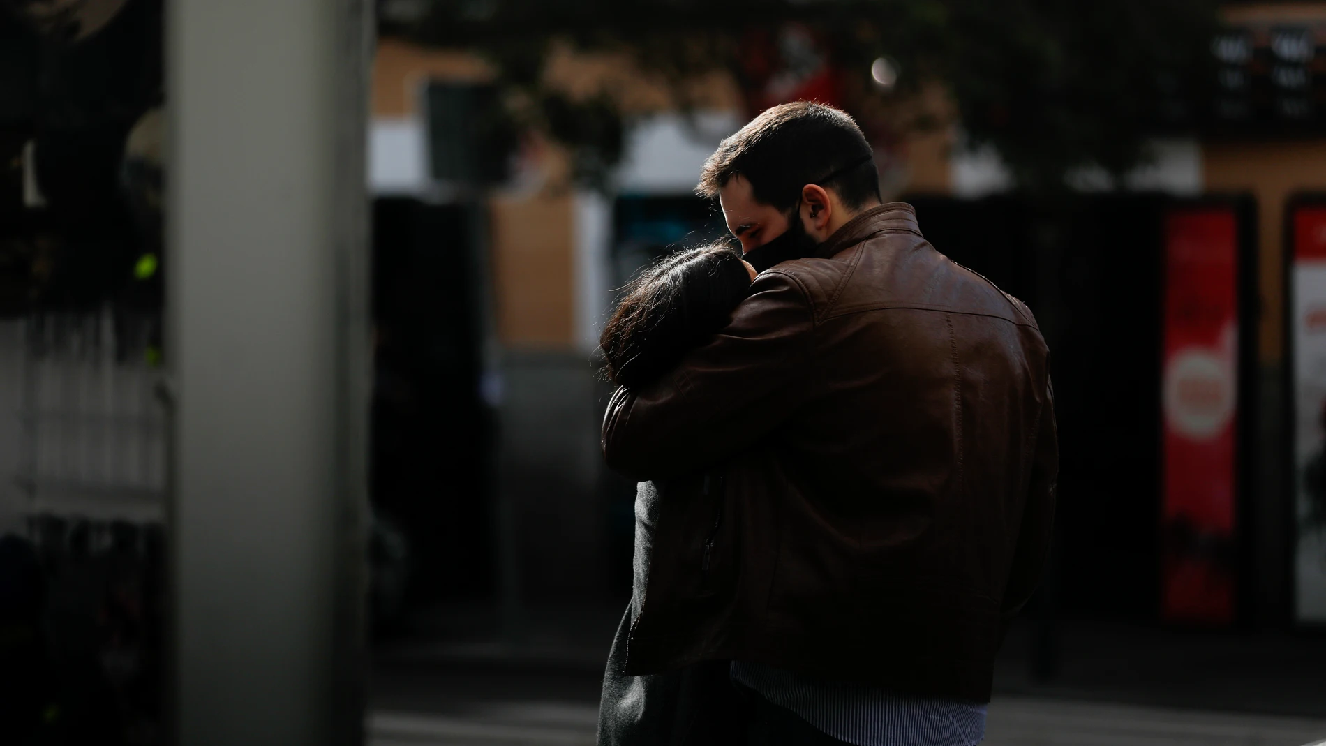 Una pareja se abraza con las mascarillas puestas en el barrio de La Latina (Madrid)