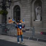 Un votante independentista forrado de esteladas frente a la fachada del Ayuntamiento de Barcelona