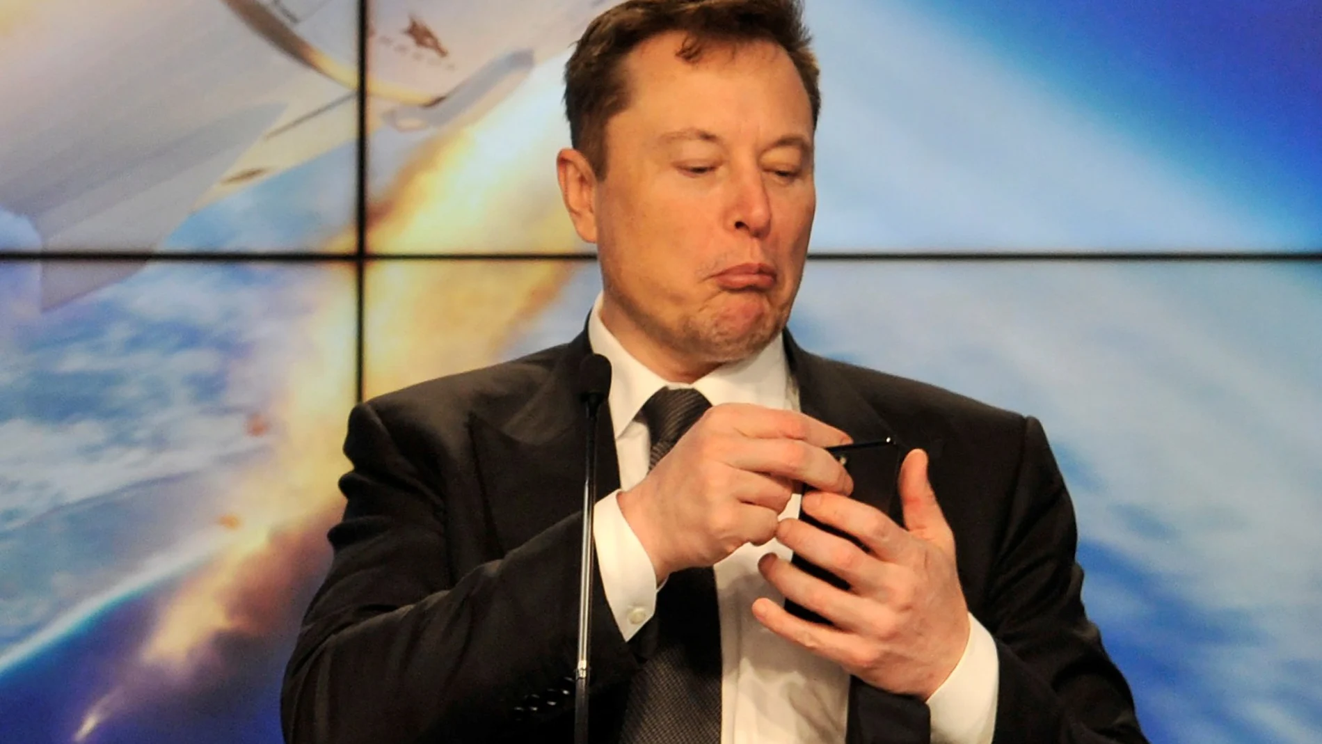 El fundador de SpaceX, Elon Musk, observa su móvil durante una rueda de prensa en Cabo Cañaveral, el año pasado
