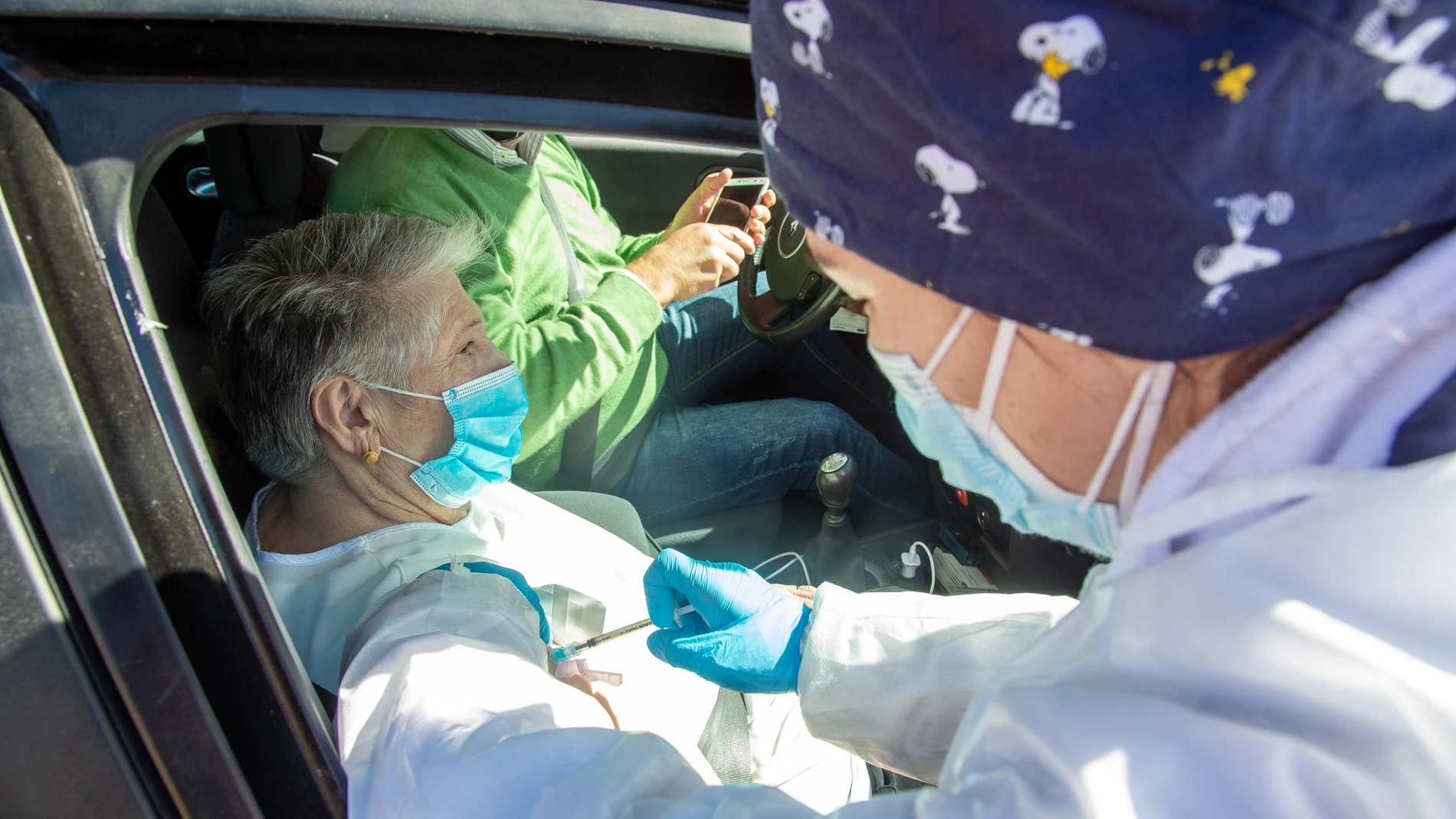 Una sanitaria inyecta la vacuna de Pfizer a una persona mayor que espera desde el coche en el exterior del Polideportivo Municipal, en Villafranca De Los Barros, Badajoz, Extremadura (España)