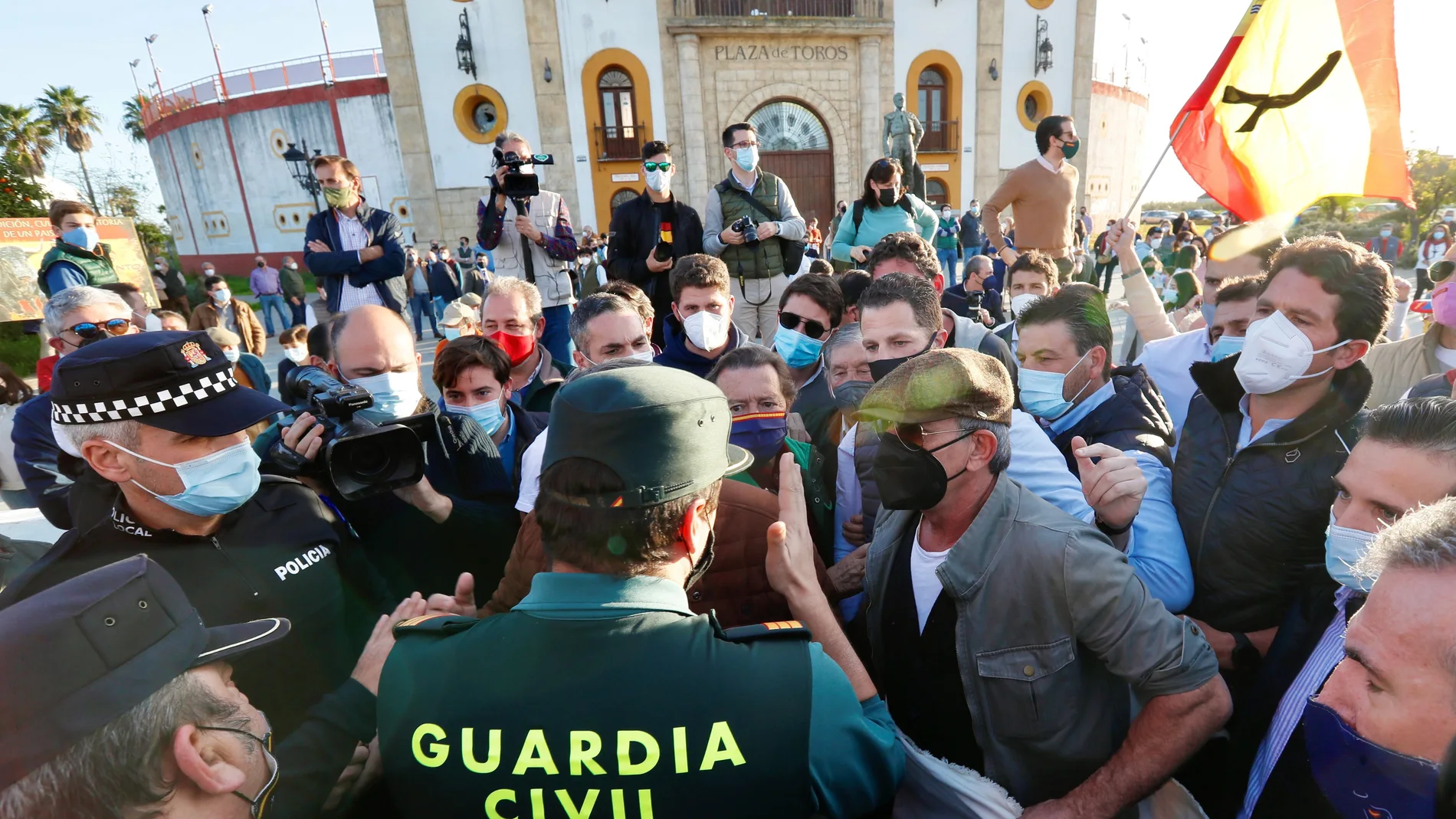 Profesionales y aficionados taurinos hablan con un agente de la Guardia Civil durante la concentración que han realizado en Espartinas