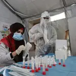 Sanitarios preparan muestran de personas antes la prueba del coronavirus en el sur de Gaza