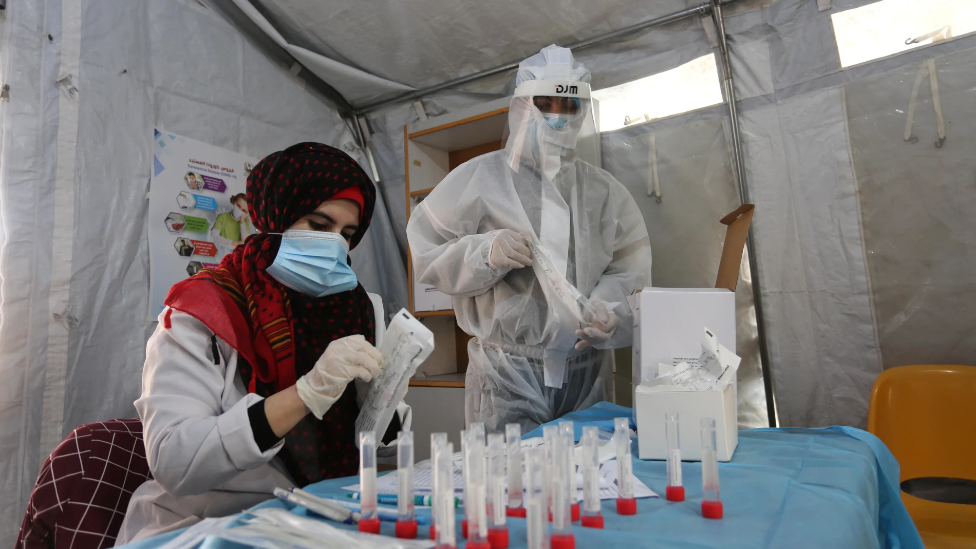 Sanitarios preparan muestran de personas antes la prueba del coronavirus en el sur de Gaza