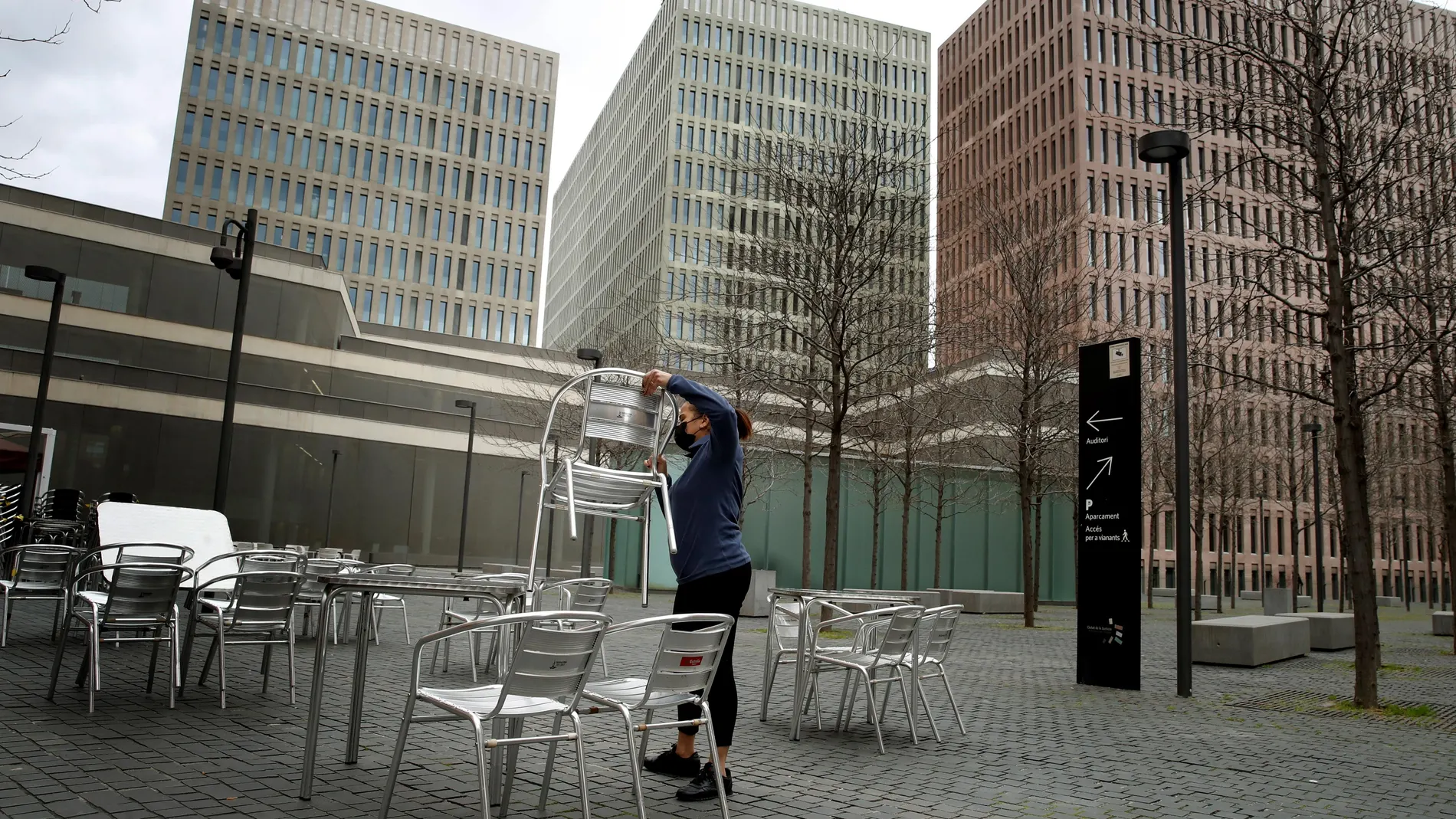 Una camarera prepara la terraza del restaurante donde trabaja para atender a sus clientes, al lado de la Ciudad Judicial en L'Hospitalet de Llobregat. EFE/Toni Albir