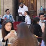 Un camarero toma nota a varios clientes en la terraza de un restaurante en la Plaza de Las Flores de Murcia