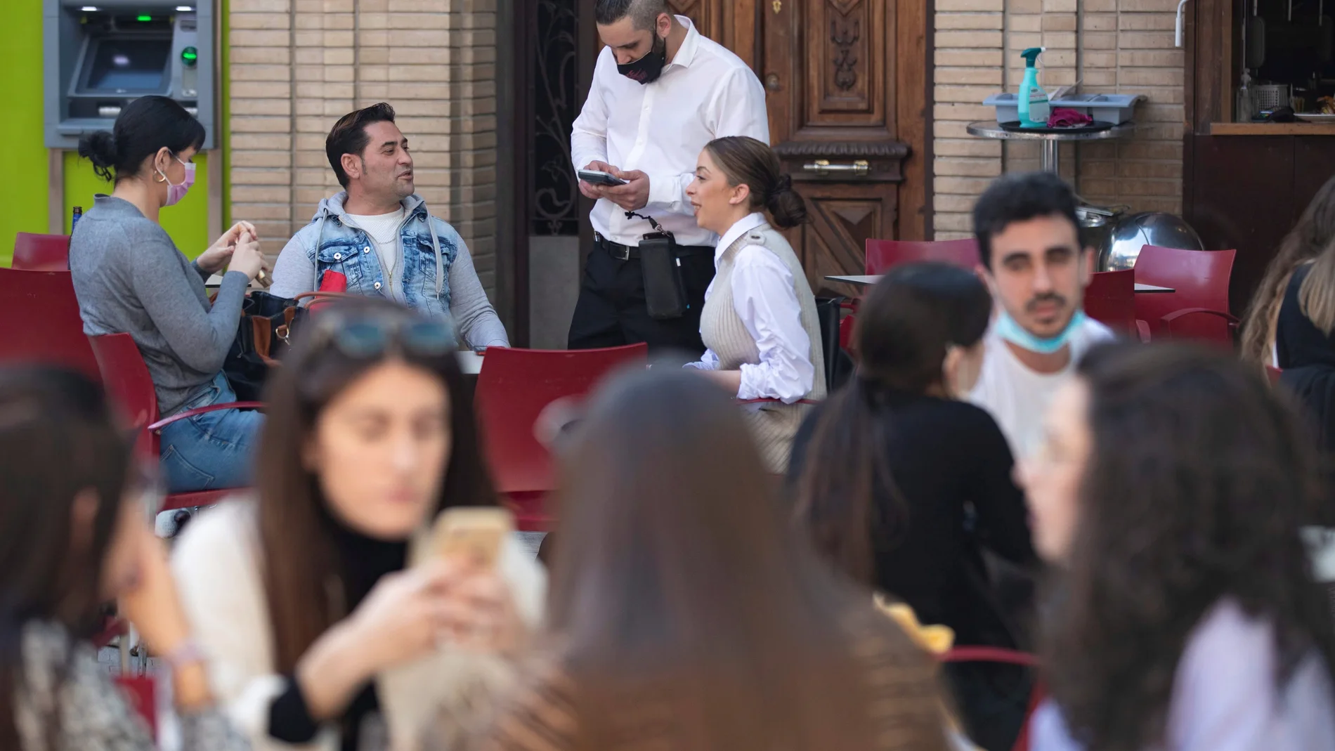 Un camarero toma nota a varios clientes en la terraza de un restaurante en la Plaza de Las Flores de Murcia