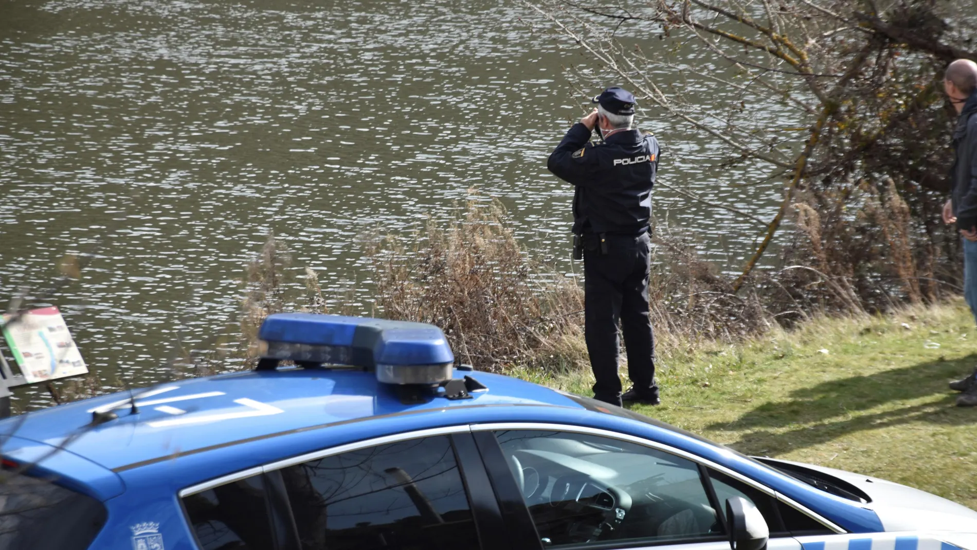 Un agente de policía durante las labores de búsqueda de un joven de 20 años que desapareció este miércoles en el cauce del río Duero, a su paso por Soria, cuando nadaba en la zona de San Prudencio, enfrente de la ermita de San Saturio. Hasta el momento, los equipos de rescate no han localizado al joven y mantienen la búsqueda con el apoyo material de una lancha y un dron. EFE/ Nacho Gallego
