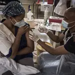 Una sanitaria recibe la vacuna en Suráfrica, país que ha negociado por su cuenta la adquisición de las dosis por un elevado precio