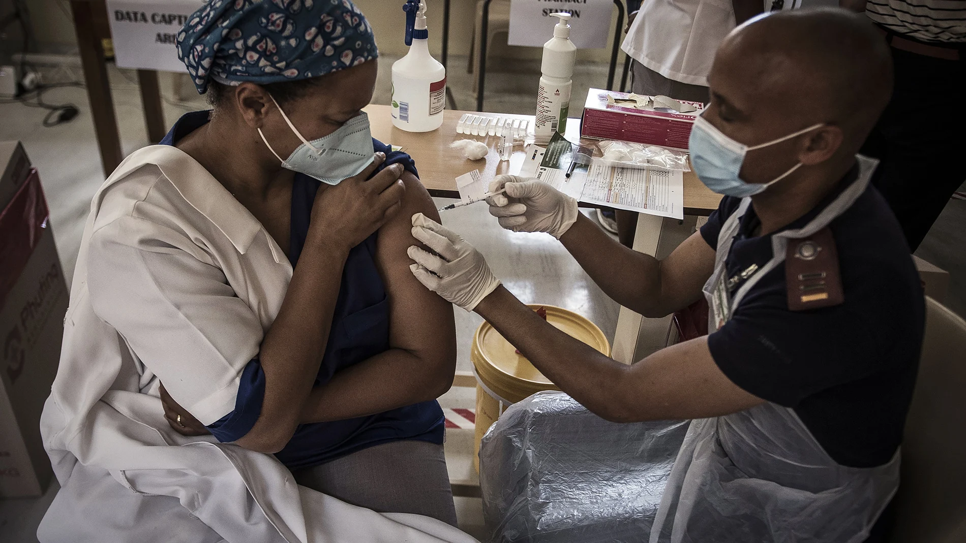 Una sanitaria recibe la vacuna en Suráfrica, país que ha negociado por su cuenta la adquisición de las dosis por un elevado precio