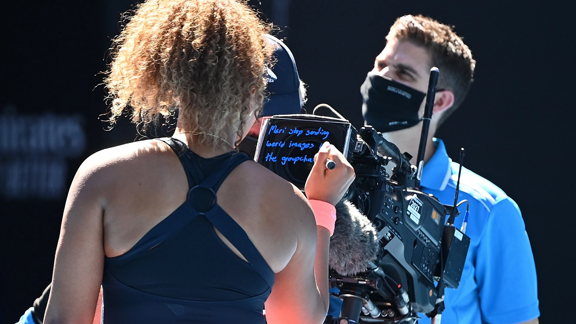 Naomi Osaka escribe un mensaje para su hermana en la cámara de televisión después de vencer a Serena Williams.