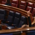 Una componente del hemiciclo vota durante una sesión plenaria en el Congreso de los Diputados