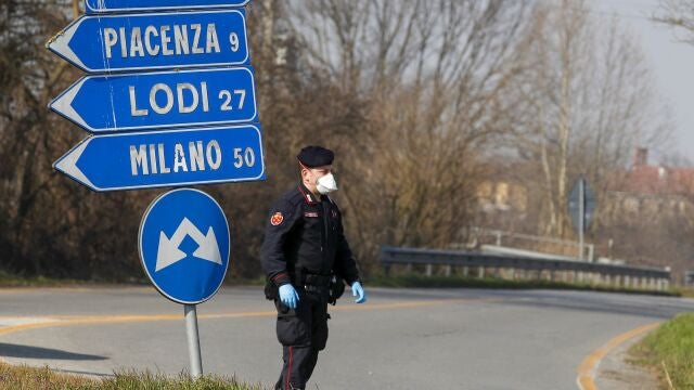 En esta fotografía de archivo del lunes 24 de febrero de 2020, un carabinieri revisa el tráfico hacia o desde el área acordonada en Codogno, a unos 50 kilómetros al sureste de Milán, Italia