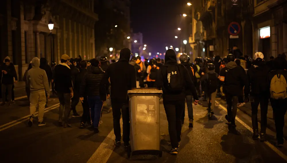 Jóvenes violentos arrastran un cubo de basura tras la manifestación contra el encarcelamiento del rapero y poeta Pablo Hasel, en Barcelona, Catalunya (España), a 19 de febrero de 2021.