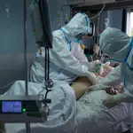 Trabajadores sanitarios atienden a un paciente con coronavirus en la UCI del Hospital Cosaga de Ourense