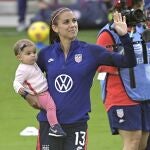 United States forward Alex Morgan (13) waves to fans in the stands while holding her daughter Charlie Elena Carrasco after a SheBelieves Cup women's soccer match against Brazil, Sunday, Feb. 21, 2021, in Orlando, Fla. (AP Photo/Phelan M. Ebenhack)