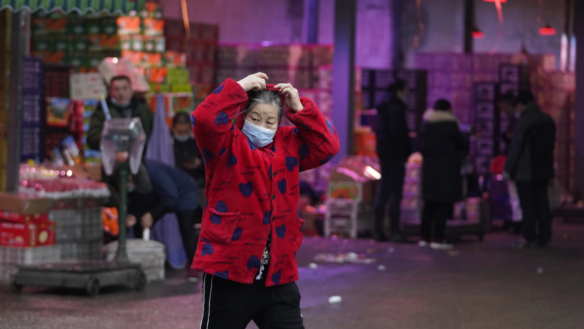 Una mujer delante del mercado de Huanan