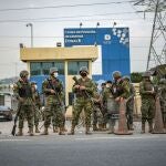 Soldados montan guardia a las puertas de una prisión donde los reclusos fueron asesinados durante un motín en Guayaquil